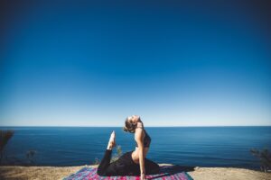 Mujer tumbada en posición de shavasana practicando yoga nidra